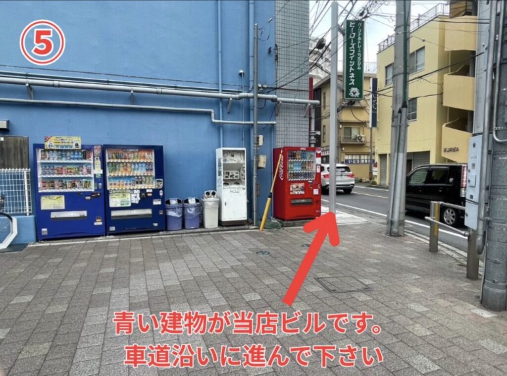 5 目の前の青い建物が当店ビルです。車道沿いに進んでください